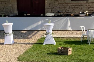 Des personnes préparent et dressent des assiettes avec des desserts dans une cuisine professionnelle.