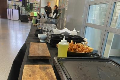 Des personnes préparent et dressent des assiettes avec des desserts dans une cuisine professionnelle.