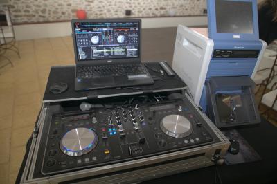 Table de mixage professionnelle avec plusieurs platines, écrans et commandes, sur fond bleu dégradé.