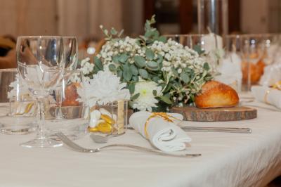 Salon ancien avec parquet en bois, mobilier classique, cheminée, miroir, coiffeuse et grande fenêtre avec rideaux roses.
