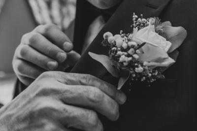Salon ancien avec parquet en bois, mobilier classique, cheminée, miroir, coiffeuse et grande fenêtre avec rideaux roses.