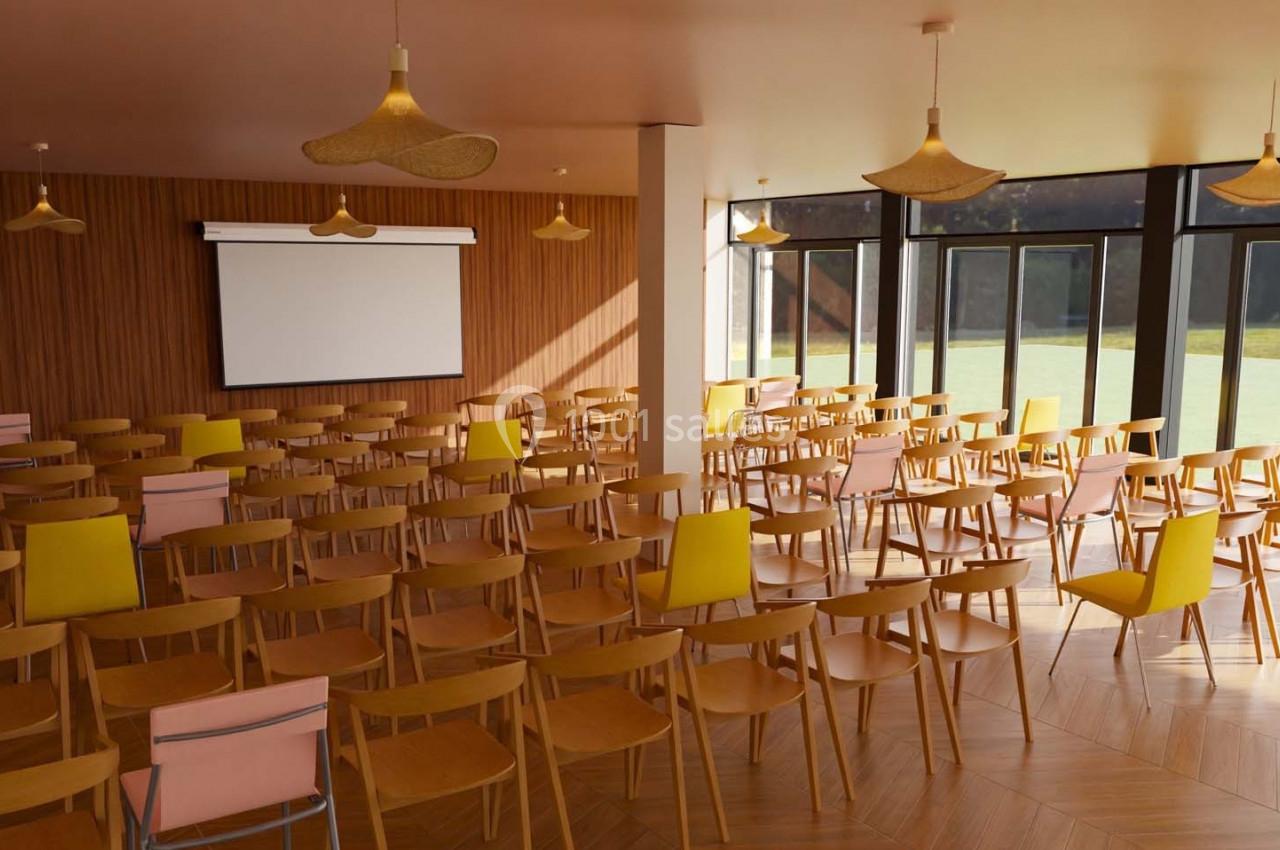 Salle de conférence lumineuse avec des rangées de chaises en bois, un écran de projection et de grandes baies vitrées.