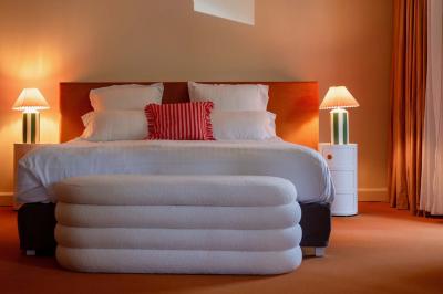 Miniature Location salle Lacanau (Gironde) - La Baignoire #28 Chambre lumineuse avec lit double, balcon donnant sur un espace arboré, rideaux rouges et lampe de chevet allumée.