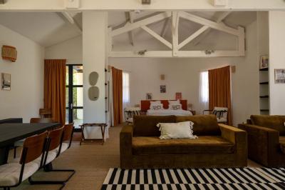 Miniature Location salle Lacanau (Gironde) - La Baignoire #21 Chambre lumineuse avec lit double, balcon donnant sur un espace arboré, rideaux rouges et lampe de chevet allumée.