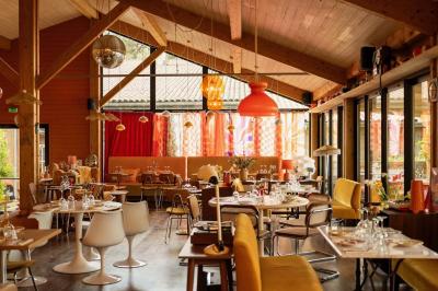 Miniature Location salle Lacanau (Gironde) - La Baignoire #11 Chambre lumineuse avec lit double, balcon donnant sur un espace arboré, rideaux rouges et lampe de chevet allumée.