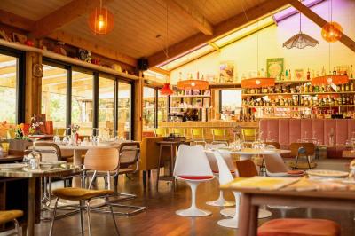 Miniature Location salle Lacanau (Gironde) - La Baignoire #9 Chambre lumineuse avec lit double, balcon donnant sur un espace arboré, rideaux rouges et lampe de chevet allumée.