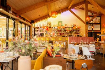 Miniature Location salle Lacanau (Gironde) - La Baignoire #10 Chambre lumineuse avec lit double, balcon donnant sur un espace arboré, rideaux rouges et lampe de chevet allumée.