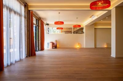 Miniature Location salle Lacanau (Gironde) - La Baignoire #8 Chambre lumineuse avec lit double, balcon donnant sur un espace arboré, rideaux rouges et lampe de chevet allumée.