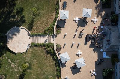 Un groupe de musiciens joue en plein air devant un grand bâtiment de style classique, entouré d'invités en tenue claire.