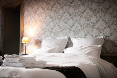 Miniature CHAMBRE D'HOTES Salle de réception lumineuse avec des tables rondes dressées, des chaises blanches et des chandeliers élégants.