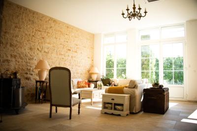 Miniature GITE LE PAVILLON Salle de réception lumineuse avec des tables rondes dressées, des chaises blanches et des chandeliers élégants.