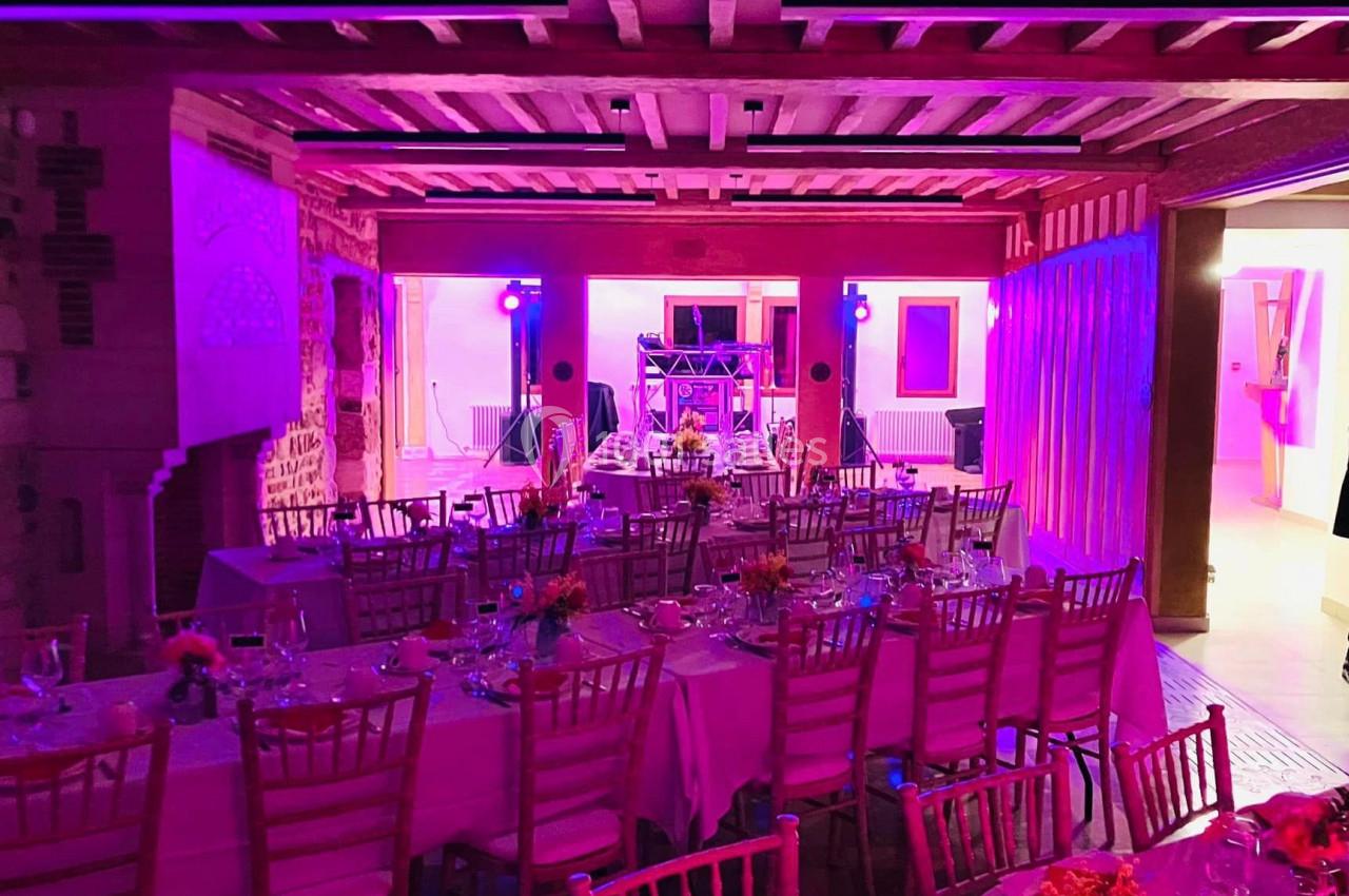 Location salle Saint-Samson-de-la-Roque (Eure) - Manoir Néo Normand #92 Salle de réception décorée avec des tables dressées et éclairage rose, prête pour un événement festif.