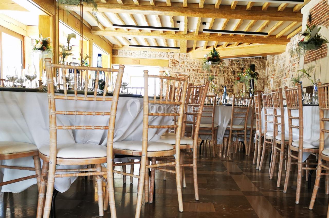 Location salle Saint-Samson-de-la-Roque (Eure) - Manoir Néo Normand #87 Salle de réception lumineuse avec tables dressées, nappes blanches et chaises en bois clair, décorée de fleurs suspendues.