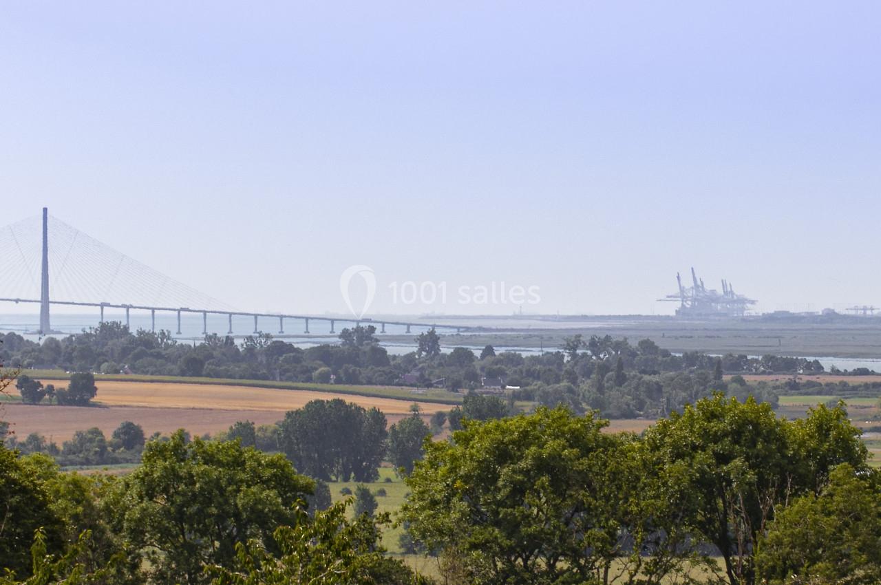 Location salle Saint-Samson-de-la-Roque (Eure) - Manoir Néo Normand #102 Paysage rural avec arbres, champs et vue lointaine sur un pont suspendu et des installations industrielles.