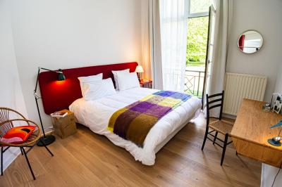 Miniature Location salle Hastière (Namur) - Les Sorbiers #17 Chambre lumineuse avec lit double, plaid coloré, bureau en bois, chaise et vue sur un jardin par une fenêtre ouverte.