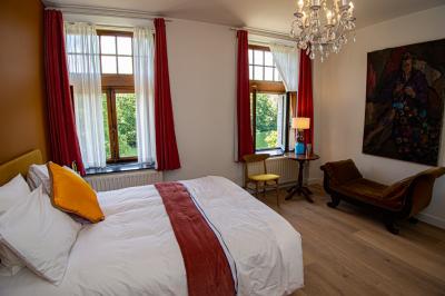 Miniature Location salle Hastière (Namur) - Les Sorbiers #16 Chambre lumineuse avec lit double, plaid coloré, bureau en bois, chaise et vue sur un jardin par une fenêtre ouverte.