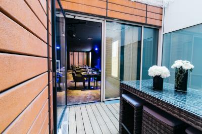 Miniature Location salle Lyon 6 (Rhône) - Casino le Pharaon #8 Terrasse en bois avec table haute en rotin, fleurs blanches et vue sur une salle de restaurant moderne éclairée.