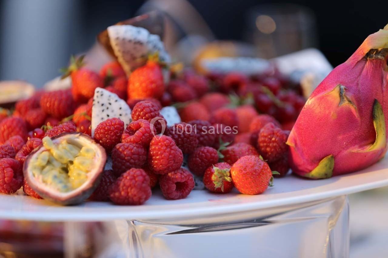 Assortiment de fruits frais comprenant des framboises, des fraises, du fruit du dragon et des fruits de la passion sur un…