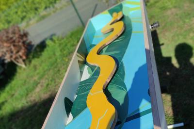 Disque en bois avec des cercles numérotés et des pions en bois disposés sur différentes zones de points.