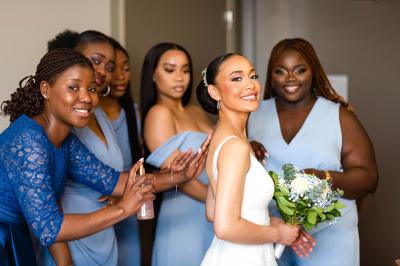 Miniature Bookman Photography #4 Un couple de mariés pose près d'une voiture ancienne blanche devant un bâtiment historique et des arbres.