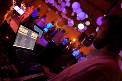 Des serveurs en tenue formelle apportent des plateaux avec des desserts ornés de cierges magiques dans une ambiance festive.