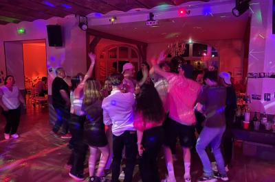 Des serveurs en tenue formelle apportent des plateaux avec des desserts ornés de cierges magiques dans une ambiance festive.