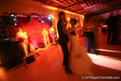 Des serveurs en tenue formelle apportent des plateaux avec des desserts ornés de cierges magiques dans une ambiance festive.