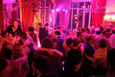 Des serveurs en tenue formelle apportent des plateaux avec des desserts ornés de cierges magiques dans une ambiance festive.