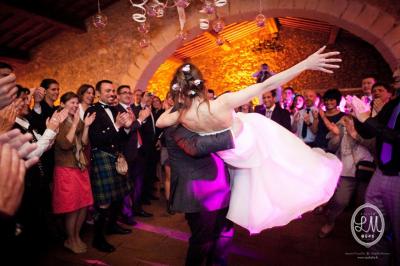 Des serveurs en tenue formelle apportent des plateaux avec des desserts ornés de cierges magiques dans une ambiance festive.