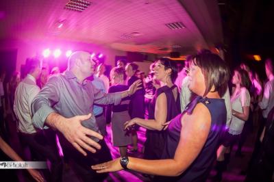 Des serveurs en tenue formelle apportent des plateaux avec des desserts ornés de cierges magiques dans une ambiance festive.