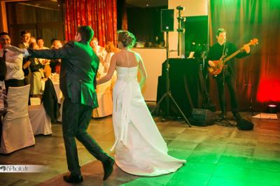 Des serveurs en tenue formelle apportent des plateaux avec des desserts ornés de cierges magiques dans une ambiance festive.