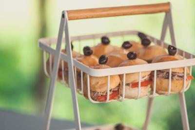 Plateau de fromages variés avec pain, raisins, confiture et couteau sur une planche en bois.