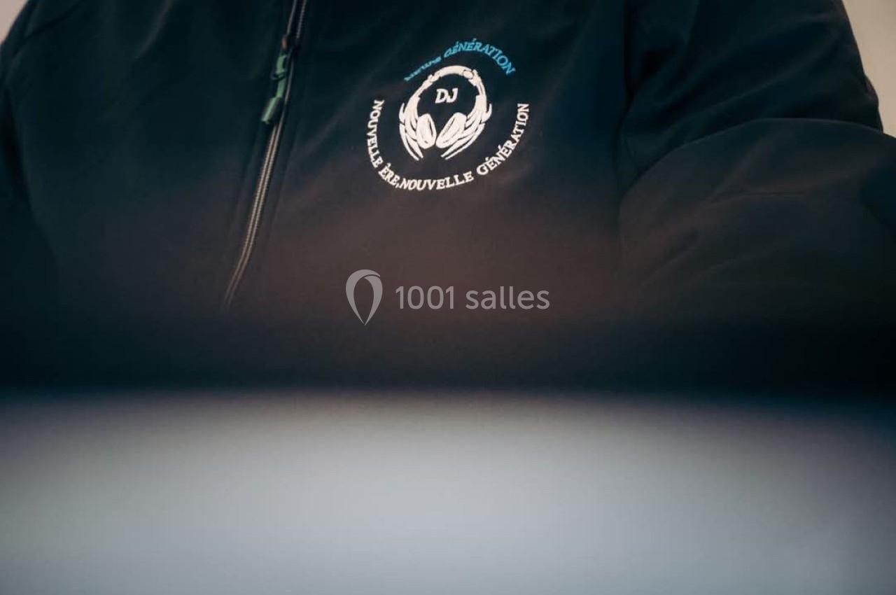 Veste noire avec un logo brodé représentant des mains entourant les lettres ’DJ’ et le texte ’Nouvelle, Renouvelle…