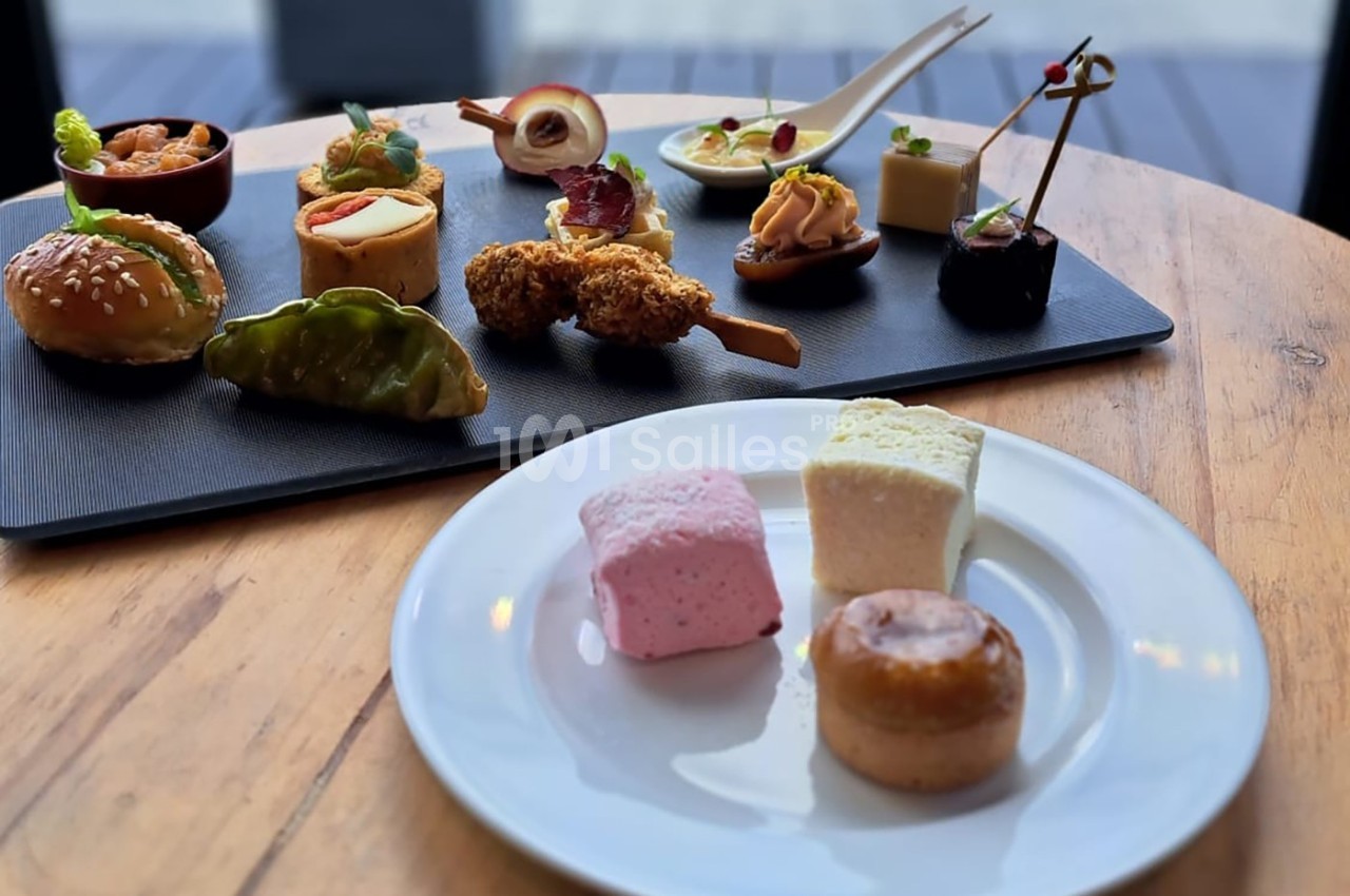 Assortiment de bouchées salées et sucrées disposées sur un plateau et une assiette en bois.
