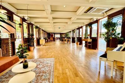 Panneau en bois indiquant les directions vers un jardin d'hiver et un boulodrome, entouré de verdure.