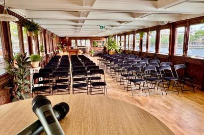 Panneau en bois indiquant les directions vers un jardin d'hiver et un boulodrome, entouré de verdure.