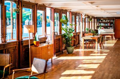 Panneau en bois indiquant les directions vers un jardin d'hiver et un boulodrome, entouré de verdure.