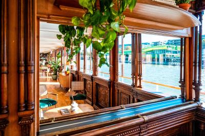 Panneau en bois indiquant les directions vers un jardin d'hiver et un boulodrome, entouré de verdure.