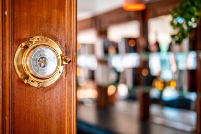 Panneau en bois indiquant les directions vers un jardin d'hiver et un boulodrome, entouré de verdure.