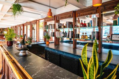 Panneau en bois indiquant les directions vers un jardin d'hiver et un boulodrome, entouré de verdure.