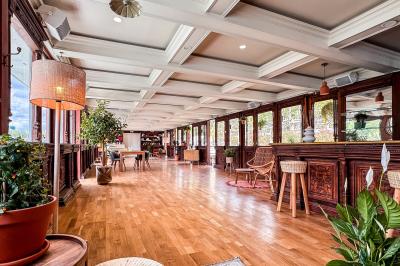 Panneau en bois indiquant les directions vers un jardin d'hiver et un boulodrome, entouré de verdure.