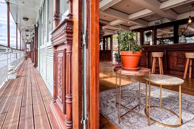 Panneau en bois indiquant les directions vers un jardin d'hiver et un boulodrome, entouré de verdure.