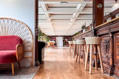 Panneau en bois indiquant les directions vers un jardin d'hiver et un boulodrome, entouré de verdure.