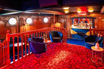 Panneau en bois indiquant les directions vers un jardin d'hiver et un boulodrome, entouré de verdure.