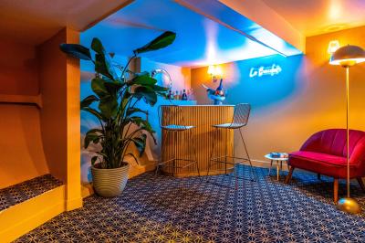 Panneau en bois indiquant les directions vers un jardin d'hiver et un boulodrome, entouré de verdure.