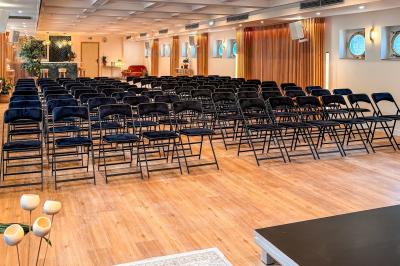 Panneau en bois indiquant les directions vers un jardin d'hiver et un boulodrome, entouré de verdure.