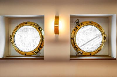 Panneau en bois indiquant les directions vers un jardin d'hiver et un boulodrome, entouré de verdure.