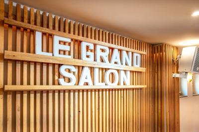 Panneau en bois indiquant les directions vers un jardin d'hiver et un boulodrome, entouré de verdure.