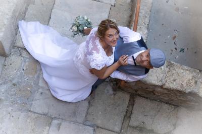 Un couple s'embrasse tendrement dans un cadre naturel entouré de branches d'olivier.