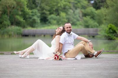 Un couple s'embrasse tendrement dans un cadre naturel entouré de branches d'olivier.